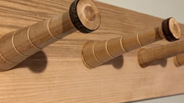 Hand-turned elm coat pegs on an ash backboard