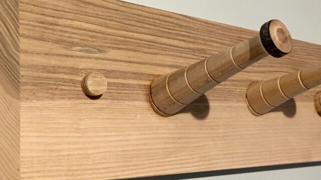Hand-turned elm coat pegs on an ash backboard